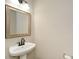 Powder room featuring a white sink, dark faucet, and framed mirror at 581 Victorian Cir, Dallas, GA 30157