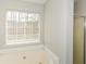 Bright bathroom featuring a soaking tub next to a shower with a window at 581 Victorian Cir, Dallas, GA 30157