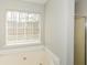 Bright bathroom featuring a soaking tub with a window view and a glass door shower at 581 Victorian Cir, Dallas, GA 30157