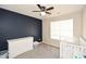 Bedroom with dark accent wall, white dresser, and cozy crib at 581 Victorian Cir, Dallas, GA 30157