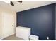 Bedroom with navy blue accent wall, white dresser and ceiling fan at 581 Victorian Cir, Dallas, GA 30157