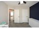 Bright bedroom with modern ceiling fan, navy accent wall, and gray carpeted floor at 581 Victorian Cir, Dallas, GA 30157