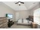 Comfortable bedroom with a ceiling fan, and entertainment system, all lit by natural light at 581 Victorian Cir, Dallas, GA 30157