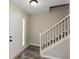 Bright foyer featuring a staircase with white railings and modern wood flooring at 581 Victorian Cir, Dallas, GA 30157