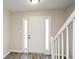 Bright foyer with staircase featuring modern flooring and a clear view of the front door at 581 Victorian Cir, Dallas, GA 30157