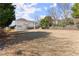 Expansive backyard view of the home featuring a deck and lush greenery at 602 Kenion Forest Way, Lilburn, GA 30047