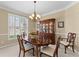 Formal dining room with elegant chandelier, wooden table, and plantation shutters at 602 Kenion Forest Way, Lilburn, GA 30047