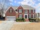 Charming brick two-story home with a well-manicured lawn and a two-car garage at 602 Kenion Forest Way, Lilburn, GA 30047