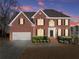 Elegant brick home at twilight with manicured landscaping and inviting curb appeal at 602 Kenion Forest Way, Lilburn, GA 30047