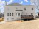 Rear exterior view of home with a deck, white siding, and well-maintained lawn at 602 Kenion Forest Way, Lilburn, GA 30047