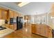 Open eat-in kitchen with wood cabinets and stainless appliances connected to breakfast nook at 602 Kenion Forest Way, Lilburn, GA 30047