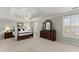 Spacious main bedroom featuring a tray ceiling, ceiling fan, and a four-post bed at 602 Kenion Forest Way, Lilburn, GA 30047