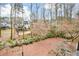 Large, beautifully landscaped backyard with a wooded area, offering privacy and a connection to nature at 608 Ridge Crossing Dr, Woodstock, GA 30189