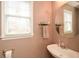 Cozy powder room featuring a stylish sink, round mirror, and ample natural light at 608 Ridge Crossing Dr, Woodstock, GA 30189