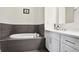 Relaxing bathroom featuring a soaking tub, white vanity, and stylish gray tiling at 625 Piedmont Ne Ave # 3028, Atlanta, GA 30308