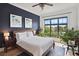 Stylish bedroom featuring a navy accent wall, natural light, and hardwood floors at 625 Piedmont Ne Ave # 3028, Atlanta, GA 30308