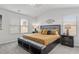 Bright bedroom featuring a large bed, two nightstands, and natural light from the windows at 7021 Old Bridge Ln, Conyers, GA 30013