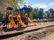 Community playground with colorful slides, climbing structures, and swings, set against a backdrop of mature trees and blue skies at 72 Hampton Ter, Dallas, GA 30157