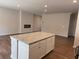 Kitchen island features granite countertops and a large open concept living area with a fireplace at 986 Southland Ln (Lot 32), Lawrenceville, GA 30043