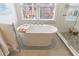 Bright bathroom with a freestanding tub and walk-in glass shower; accented with neutral color palette and fixtures at 1074 Fairway Ne Ests, Atlanta, GA 30319