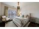 Comfortable bedroom with a decorative chandelier, large windows, and neutral decor at 1074 Fairway Ne Ests, Atlanta, GA 30319