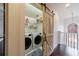 Well-lit laundry room featuring modern appliances and a decorative barn door at 1074 Fairway Ne Ests, Atlanta, GA 30319