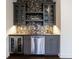 Modern wet bar with gray cabinets, wine cooler, stainless steel dishwasher, and unique backsplash at 1074 Fairway Ne Ests, Atlanta, GA 30319