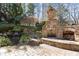 Stone fireplace and waterfall feature add charm to the outdoor living space in this backyard at 112 Rocky Creek Trl, Woodstock, GA 30188