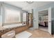 Spa-like bathroom with soaking tub, glass shower, and travertine tile at 112 Rocky Creek Trl, Woodstock, GA 30188