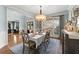 Bright dining room with a long table, chandelier, and seamless flow into the office at 112 Rocky Creek Trl, Woodstock, GA 30188