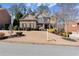 Attractive brick-and-stone home with symmetrical design, shutters, manicured bushes and a green lawn at 112 Rocky Creek Trl, Woodstock, GA 30188