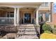 Inviting front porch with stone steps and stately columns leading to the front door at 112 Rocky Creek Trl, Woodstock, GA 30188