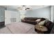 Bright living room with a large, comfortable leather sectional sofa and neutral carpet at 112 Rocky Creek Trl, Woodstock, GA 30188