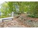 A large, detached garage sits aside a stone retaining wall and a stone patio under a canopy of green trees at 1748 Alvarado Sw Ter, Atlanta, GA 30310