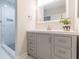 Bathroom with a gray vanity, framed mirror, modern lighting, and a glimpse into the tiled shower at 1748 Alvarado Sw Ter, Atlanta, GA 30310