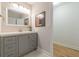 Bathroom with a gray vanity, framed mirror, modern lighting, and a glimpse into the shower at 1748 Alvarado Sw Ter, Atlanta, GA 30310