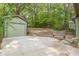 A detached garage and large concrete parking area features a bench seat and a terraced stone retaining wall at 1748 Alvarado Sw Ter, Atlanta, GA 30310