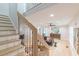 Open-concept living room featuring a modern staircase, light wood floors, and a stylish gray sofa at 1748 Alvarado Sw Ter, Atlanta, GA 30310