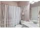 Bathroom featuring single sink vanity with toilet and a shower behind a decorative curtain at 3538 Lily Magnolia Ct, Buford, GA 30519