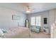 Well-lit bedroom showing bed, mirror, and a small sofa under a window with shutters at 3538 Lily Magnolia Ct, Buford, GA 30519