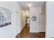 Hallway featuring hardwood floors and white walls with decorative artwork at 3538 Lily Magnolia Ct, Buford, GA 30519