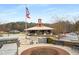 Community center featuring an American flag, covered pavilion, clock tower, and ample parking at 5229 Noble Village Way, Lilburn, GA 30047