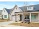 Charming exterior of a painted brick home featuring a covered front porch and attached garage at 5229 Noble Village Way, Lilburn, GA 30047