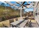 Backyard space for outdoor dining and relaxation, featuring a pergola with lights, and a barbecue grill at 690 Floral Pl, Suwanee, GA 30024