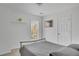 Bedroom featuring a metal bed frame, neutral walls, a window with blinds, and an adjacent door at 690 Floral Pl, Suwanee, GA 30024