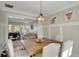 Dining room open to living space includes a wooden table, wainscoting, and modern pendant lighting at 690 Floral Pl, Suwanee, GA 30024