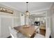 Dining room boasts wainscoting, a wooden table, and seamless flow to the adjacent living spaces at 690 Floral Pl, Suwanee, GA 30024