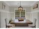 Bright dining room features wainscoting, a wooden table, and a stylish pendant light fixture at 690 Floral Pl, Suwanee, GA 30024