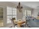 Cozy dining area connected to living room; features stylish chandelier, and bright windows at 690 Floral Pl, Suwanee, GA 30024