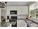 Kitchen with granite counters, subway tile backsplash, stainless appliances, and white cabinets at 690 Floral Pl, Suwanee, GA 30024